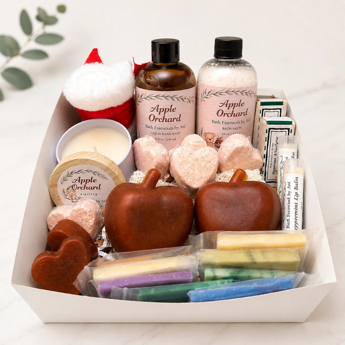 Apple-themed gift basket filled with apple-shaped soaps, candle, and packaged bath items