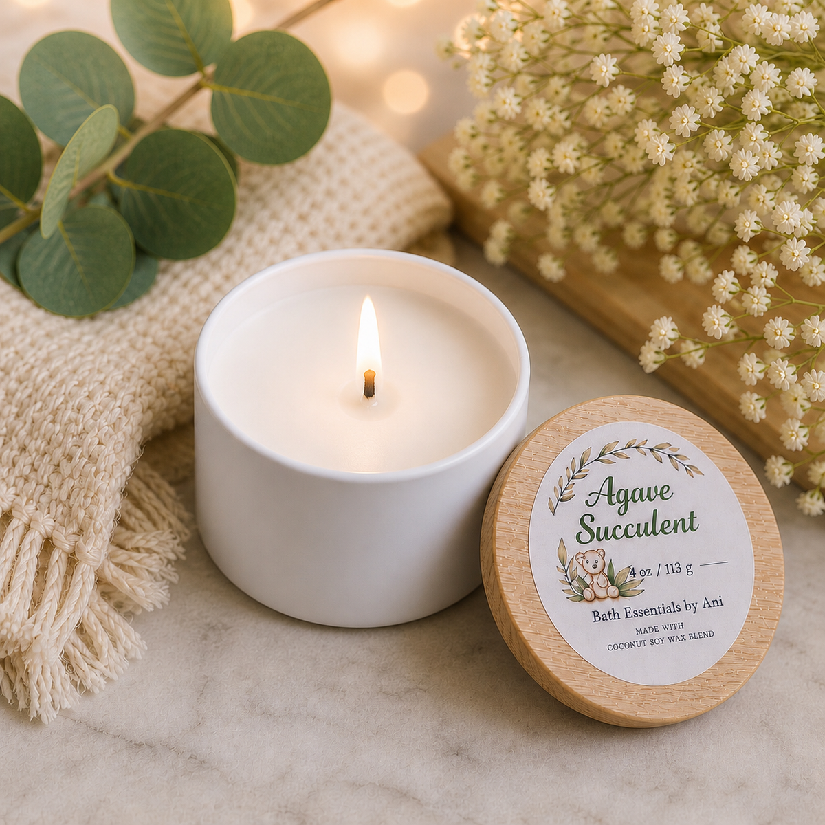 Bath essence set with lit white candle and round agave succulent tin on marble