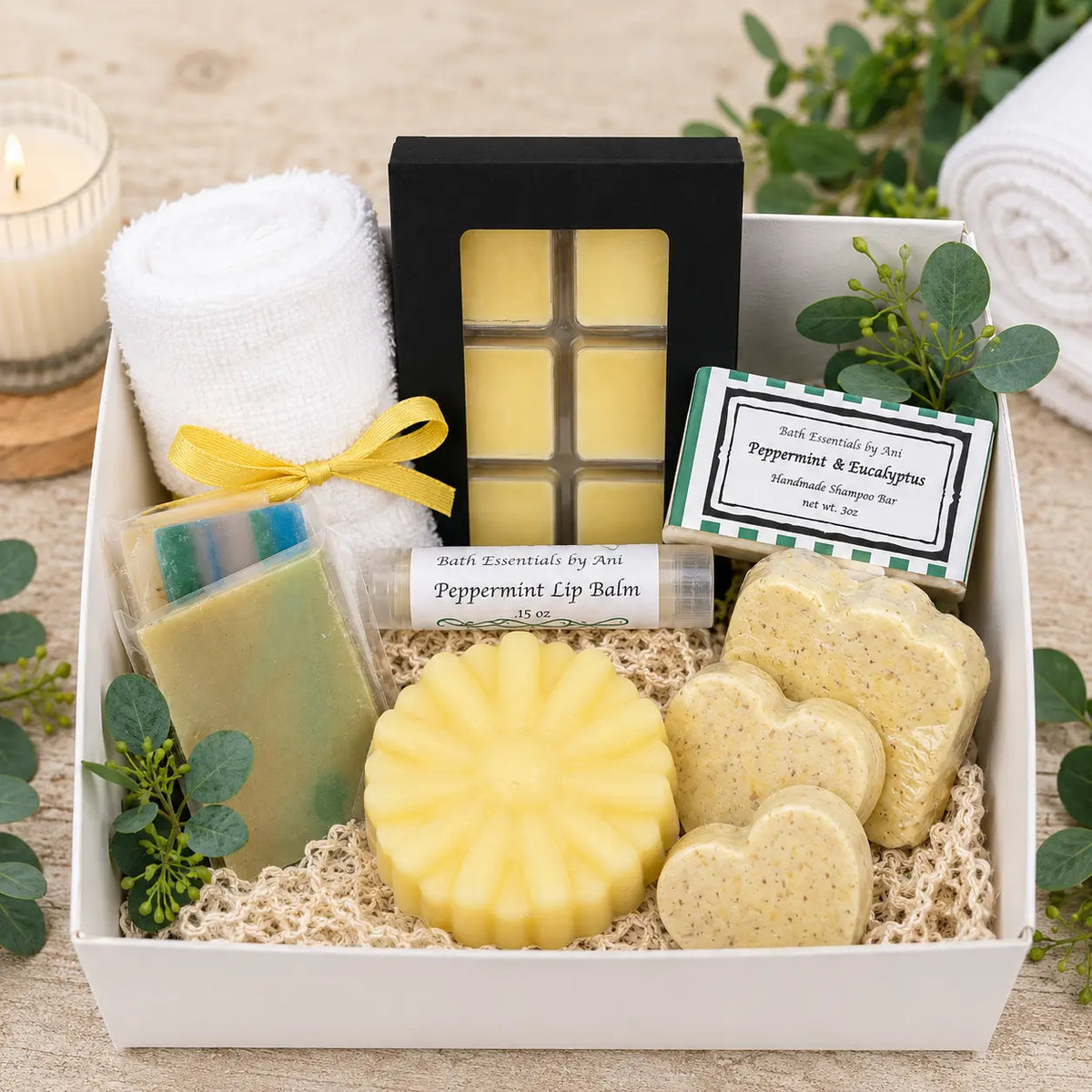 Bath gift box with white towel, yellow soap bars, and square wax melts