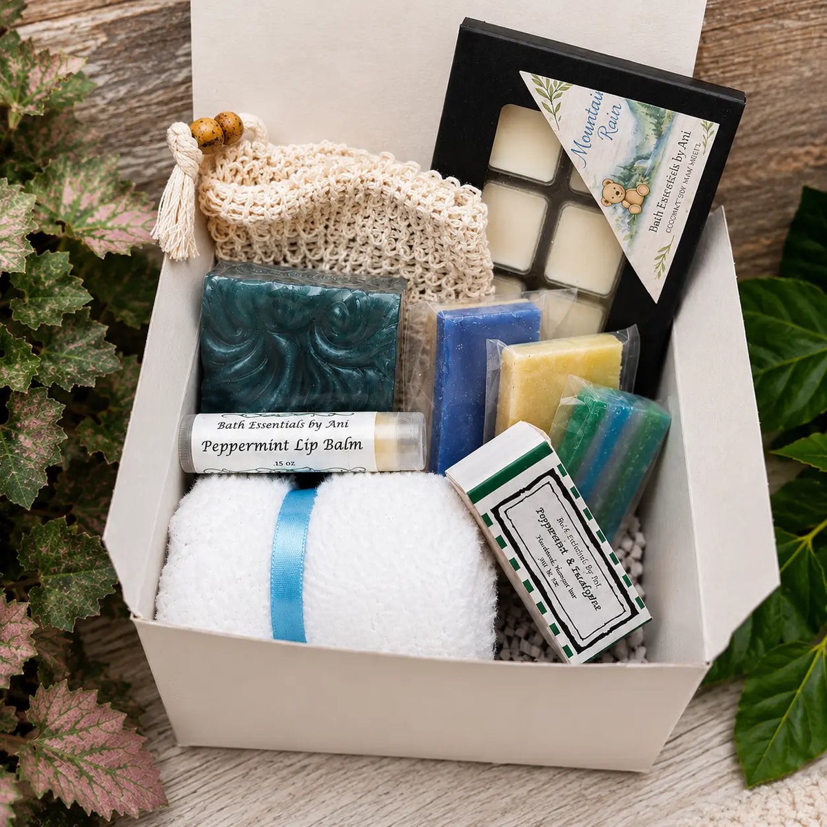 Bath gift box with teal soap bars, wax melts, lip balm, and knit scrub pouch