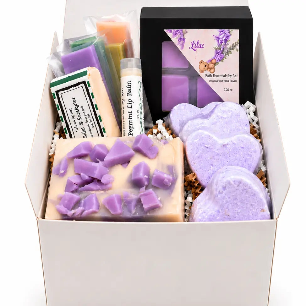 Open spa gift box with lilac soap bars, heart bath bombs, and black presentation box