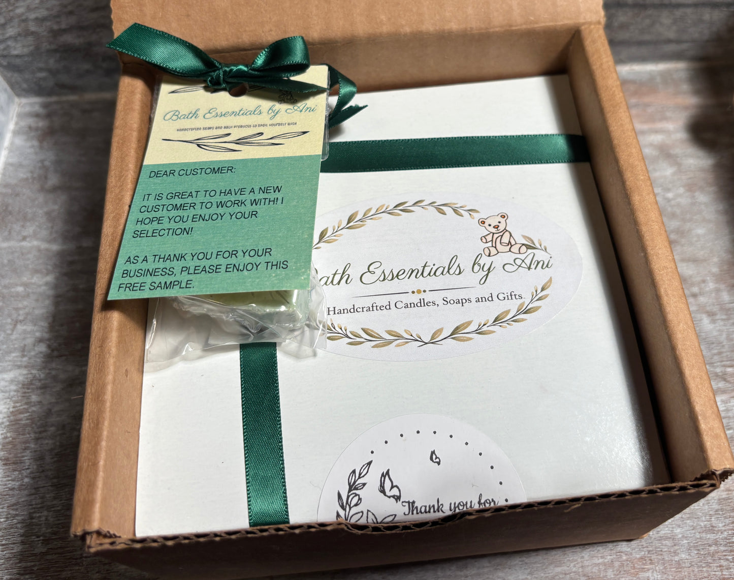 Bath essentials gift box with green ribbon and small instruction card, soaps inside