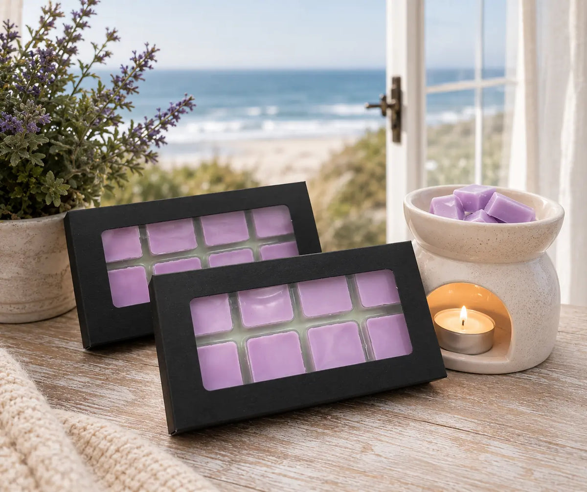 purple lilac wax melt squares set in a black box with a clear window sitting next to a wax melter