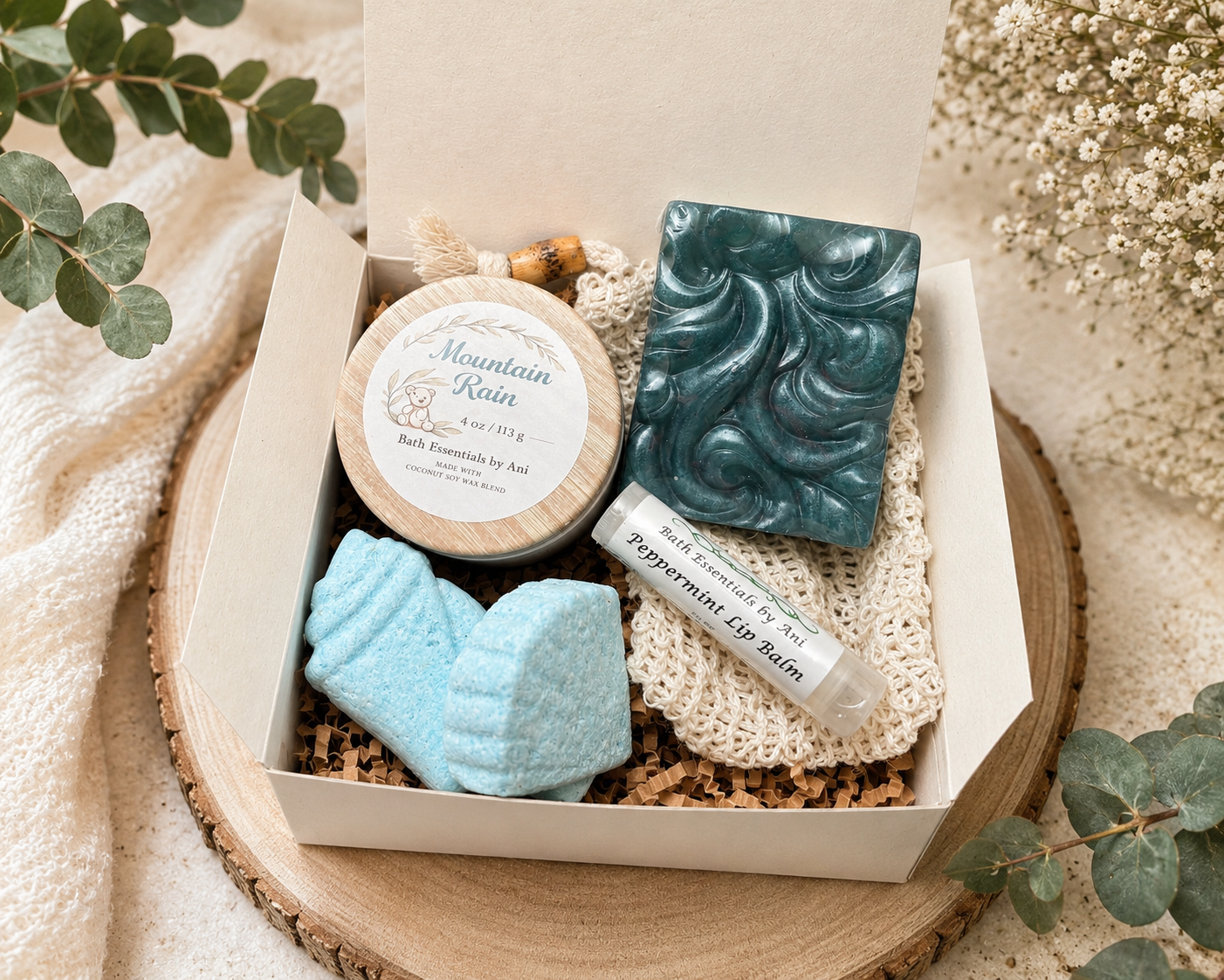 Small gift box with teal swirled soap bar, blue star bath bombs, and lip balm