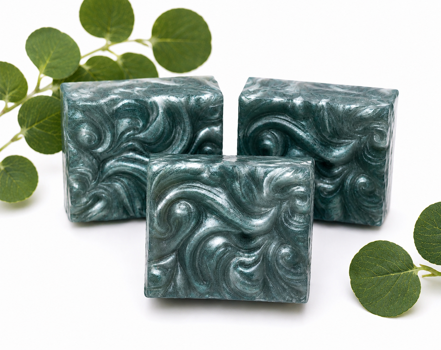 Set of three teal swirled handmade soap bars with marbled swirl patterns