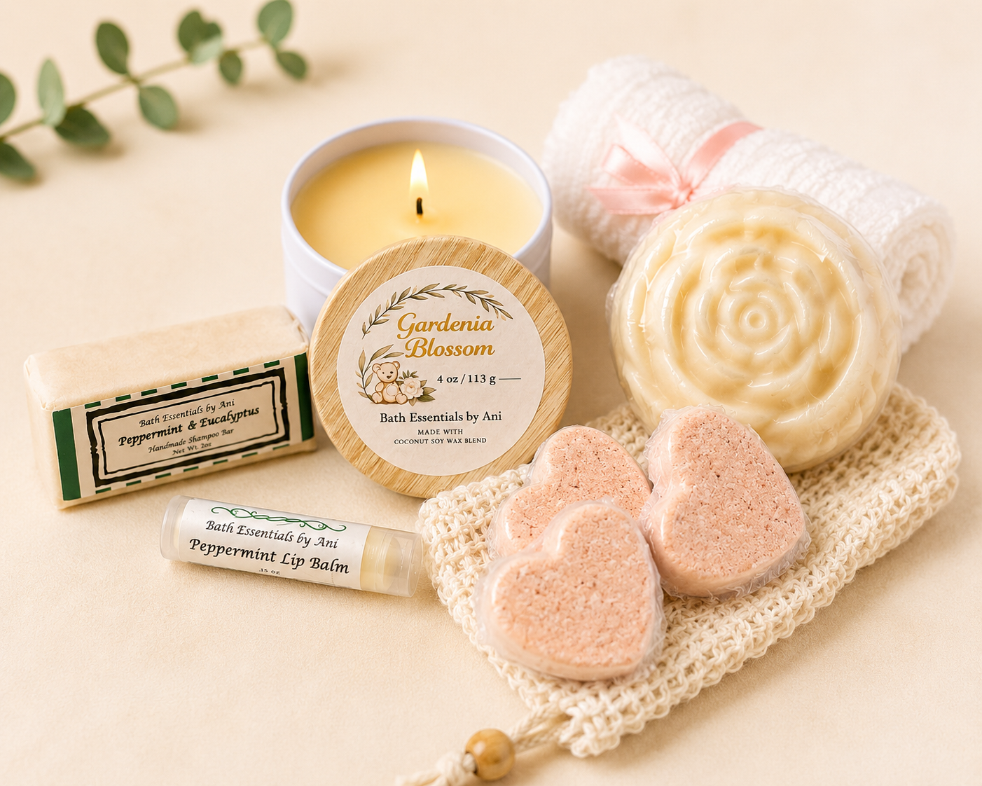 Candle with round label, swirl cream soap, pink heart soap bars, and balm tube.