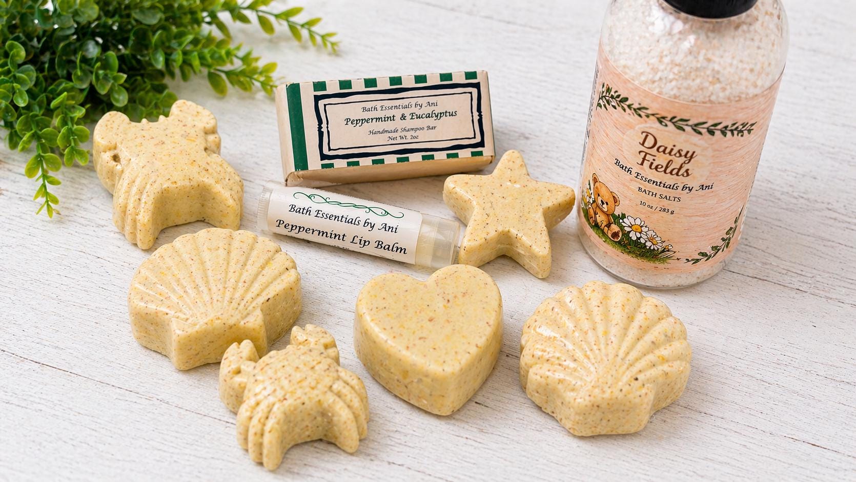 Assorted yellow handmade soap shapes with a folded washcloth and bath lip balm tubes