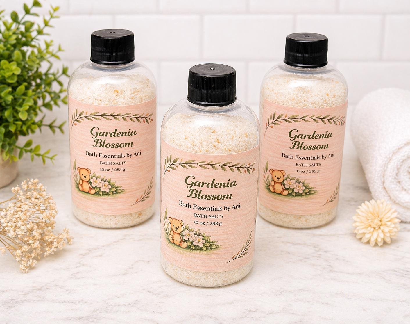 Gardenia Blossom bath essentials bottles set with black caps on white background