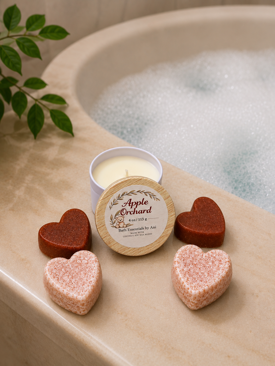Apple Orchard scented candle tin beside heart-shaped bath soaps in dark and pink shades