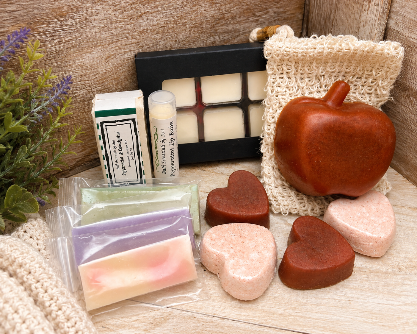 Spa gift set on wooden surface with apple-shaped soap, wax melts, and loofah pouch