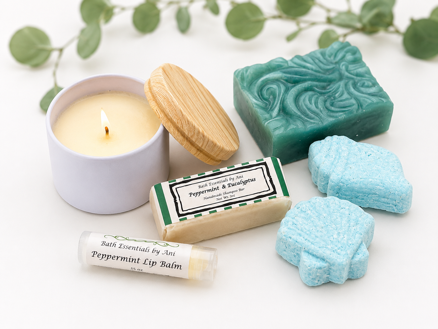 Bath essentials set with teal soap bar, blue star bath bombs, and candle