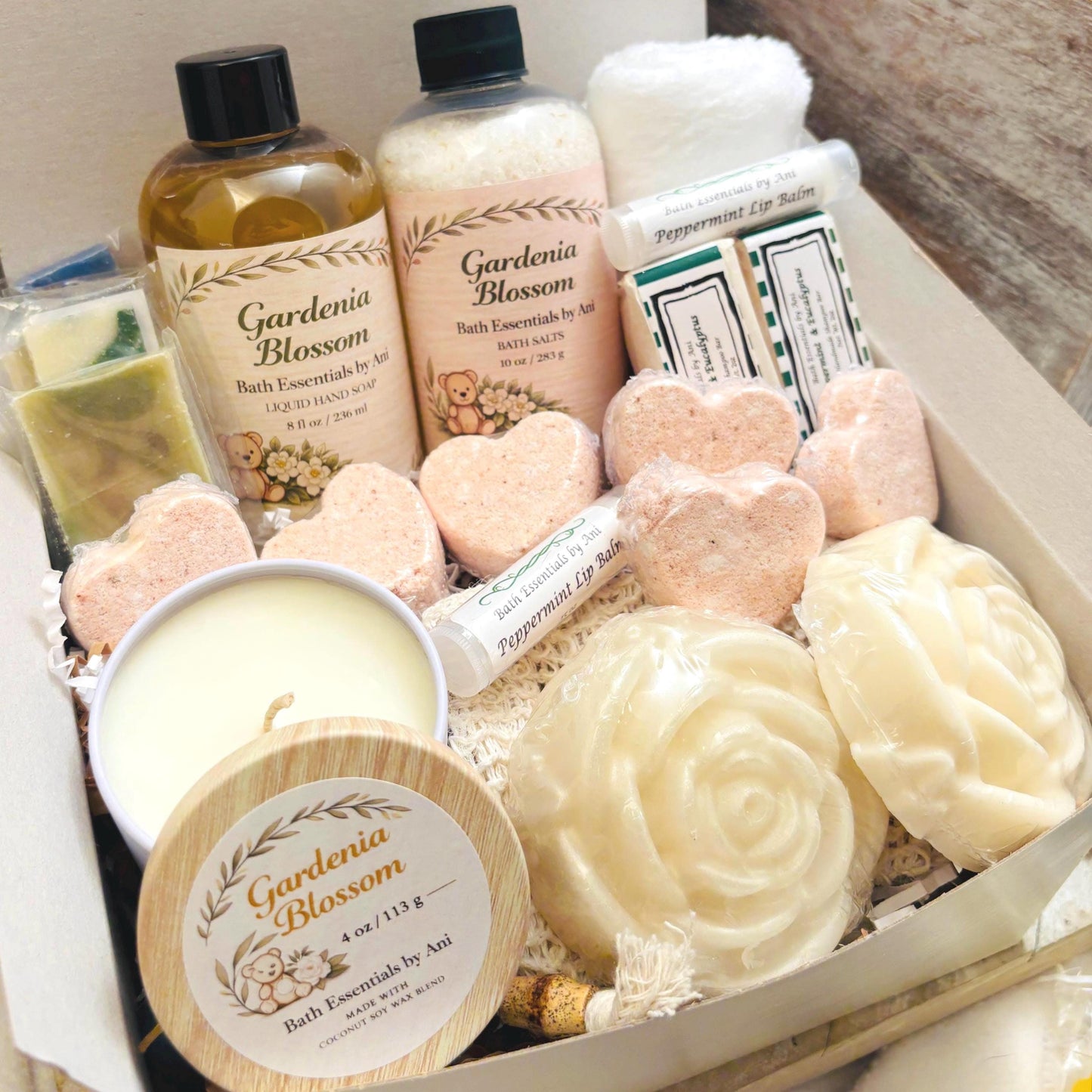 Spa gift box with candle, cream soap bars, bath salts, and bath essentials in a tray.