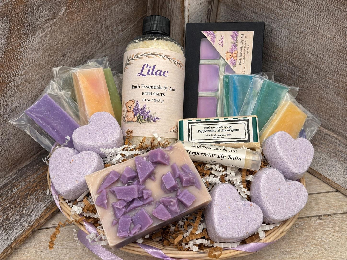 Spa gift set on a woven basket with purple bath hearts, soap cubes, and lilac bottle