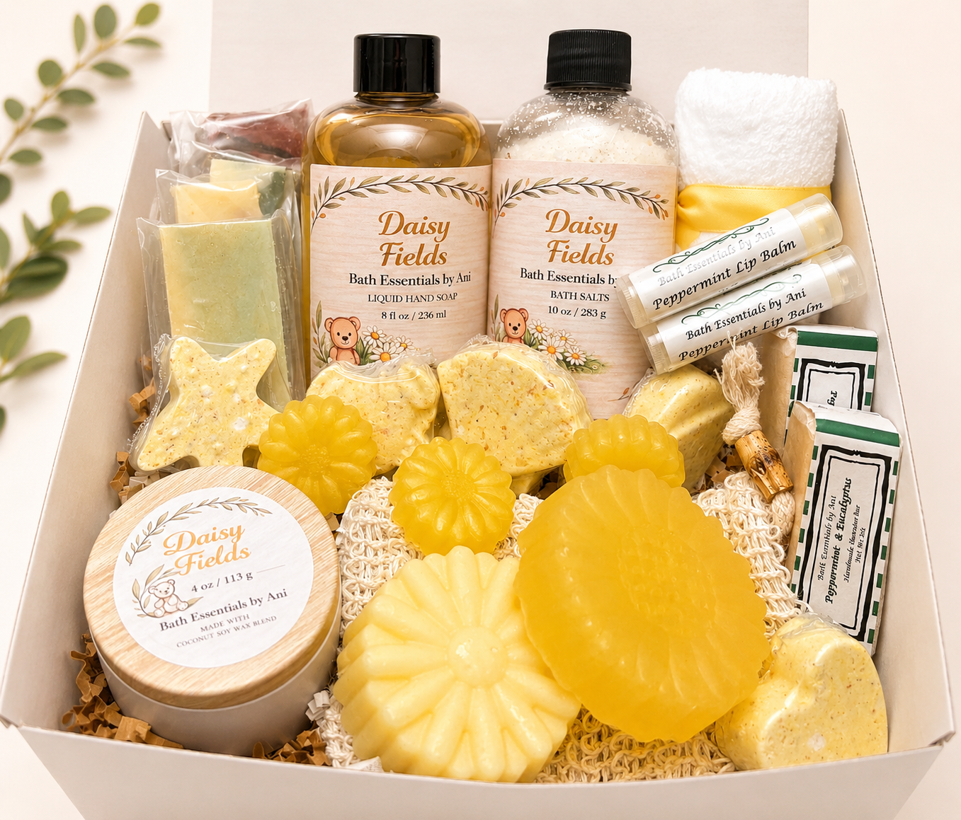 Spa gift basket with yellow daisy bath soaps, bath bombs, and candle in open box