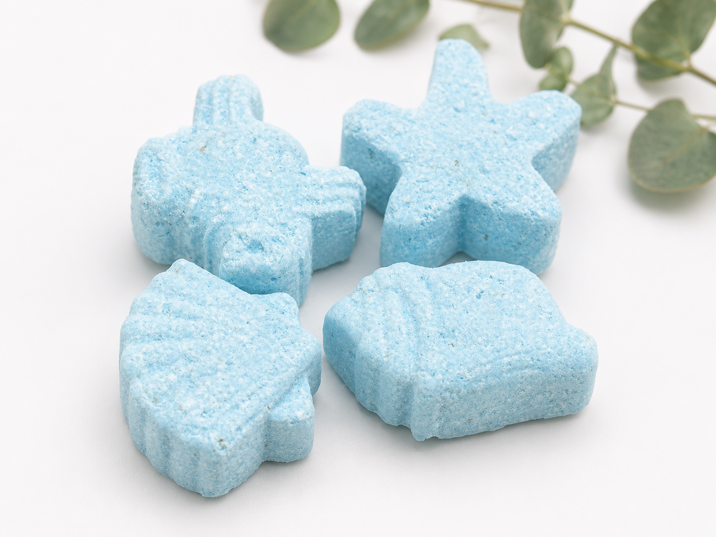 Blue star-shaped bath bombs stacked together on a light background