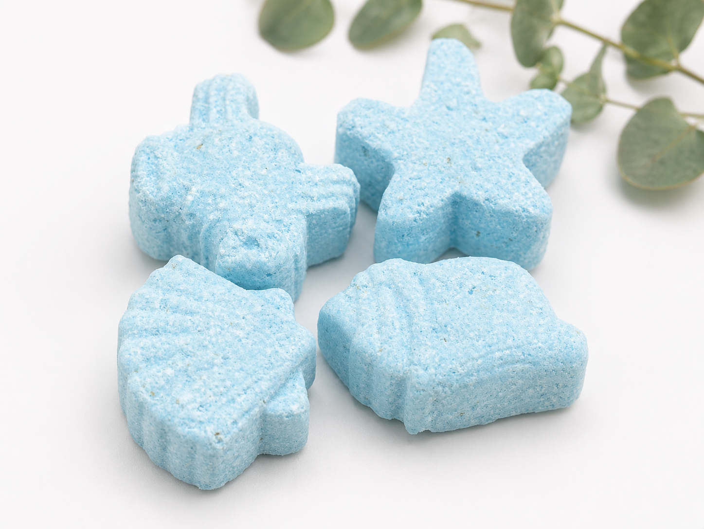 Blue star-shaped bath bombs stacked together on a light background
