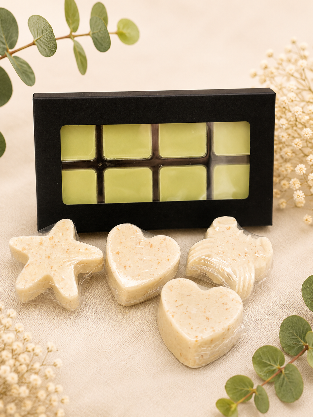 Assorted heart-shaped soaps beside a window gift box with yellow soap grid