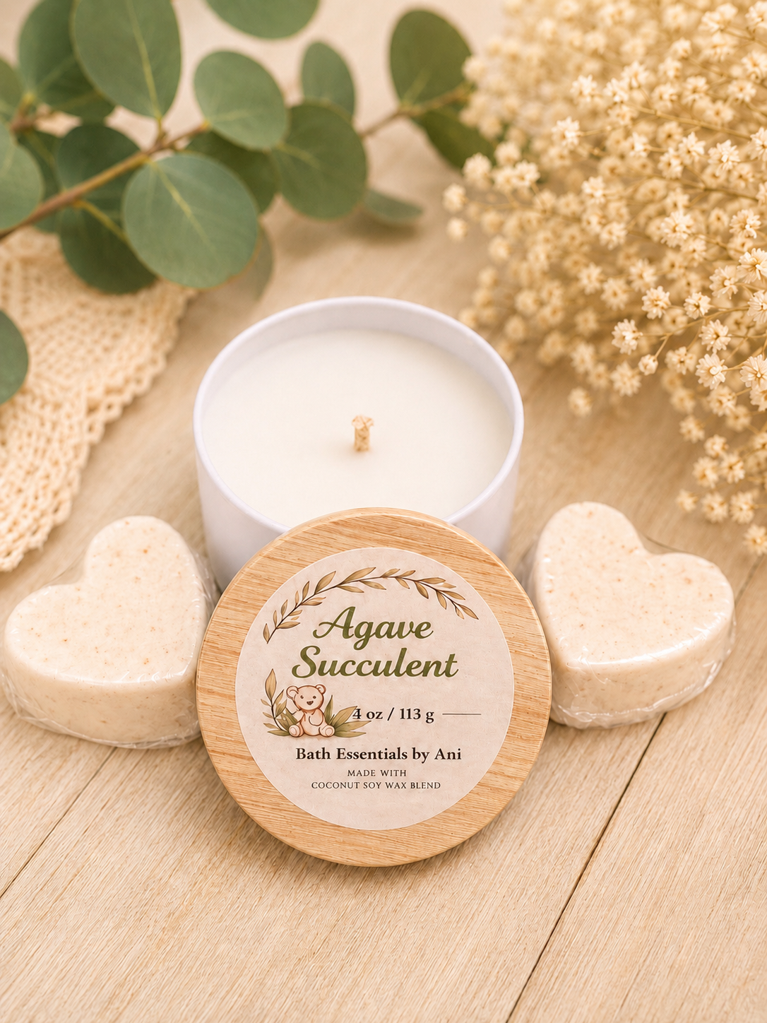 Bath essence set with lit candle, heart-shaped soaps, and round agave succulent tin