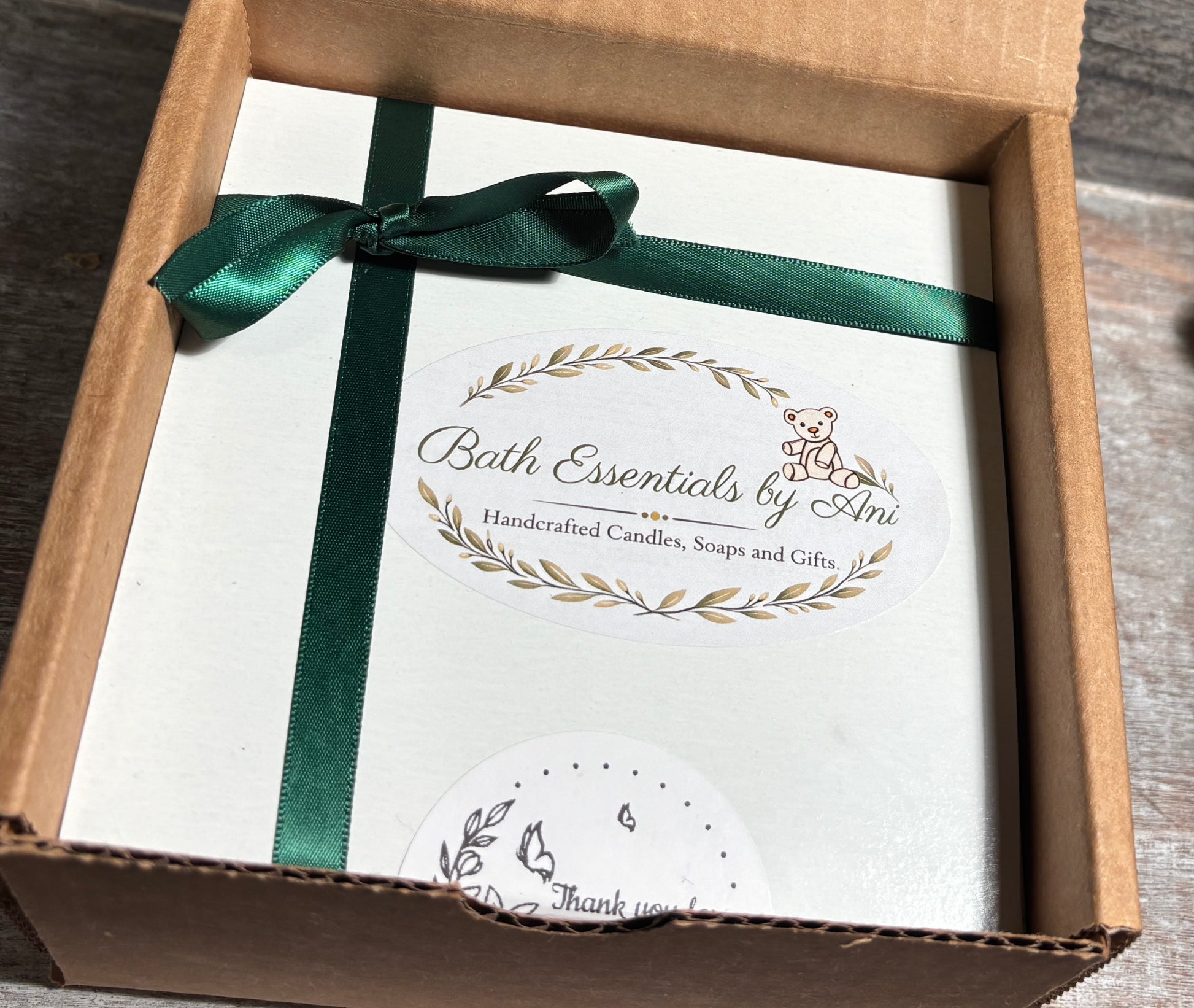 Bath essentials gift set box with green ribbon and printed greeting card