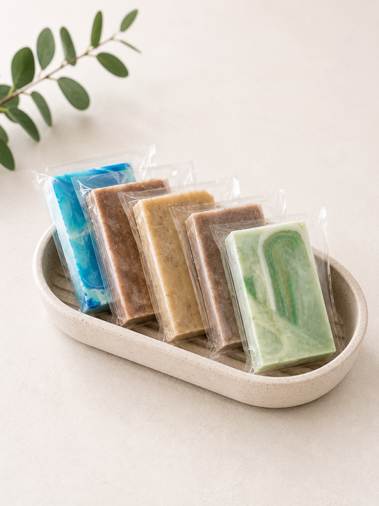 Wrapped mini soap bars assortment in a white ceramic dish, assorted colors