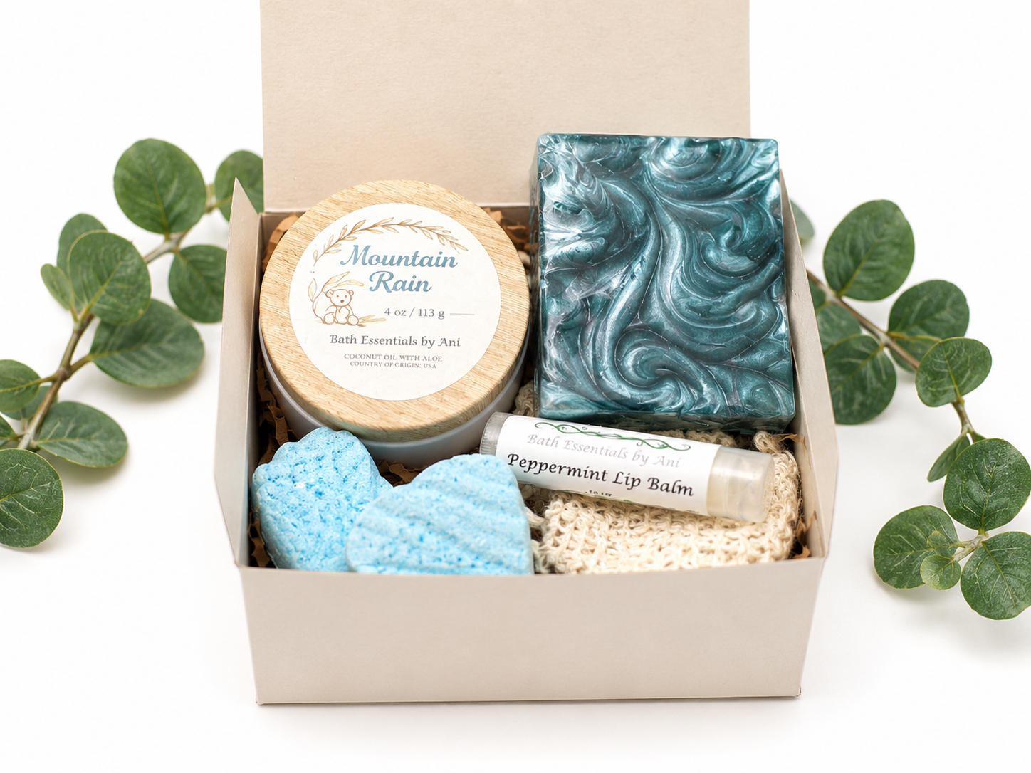 Small gift box with teal swirled soap bar, blue bath bombs, and lip balm tube