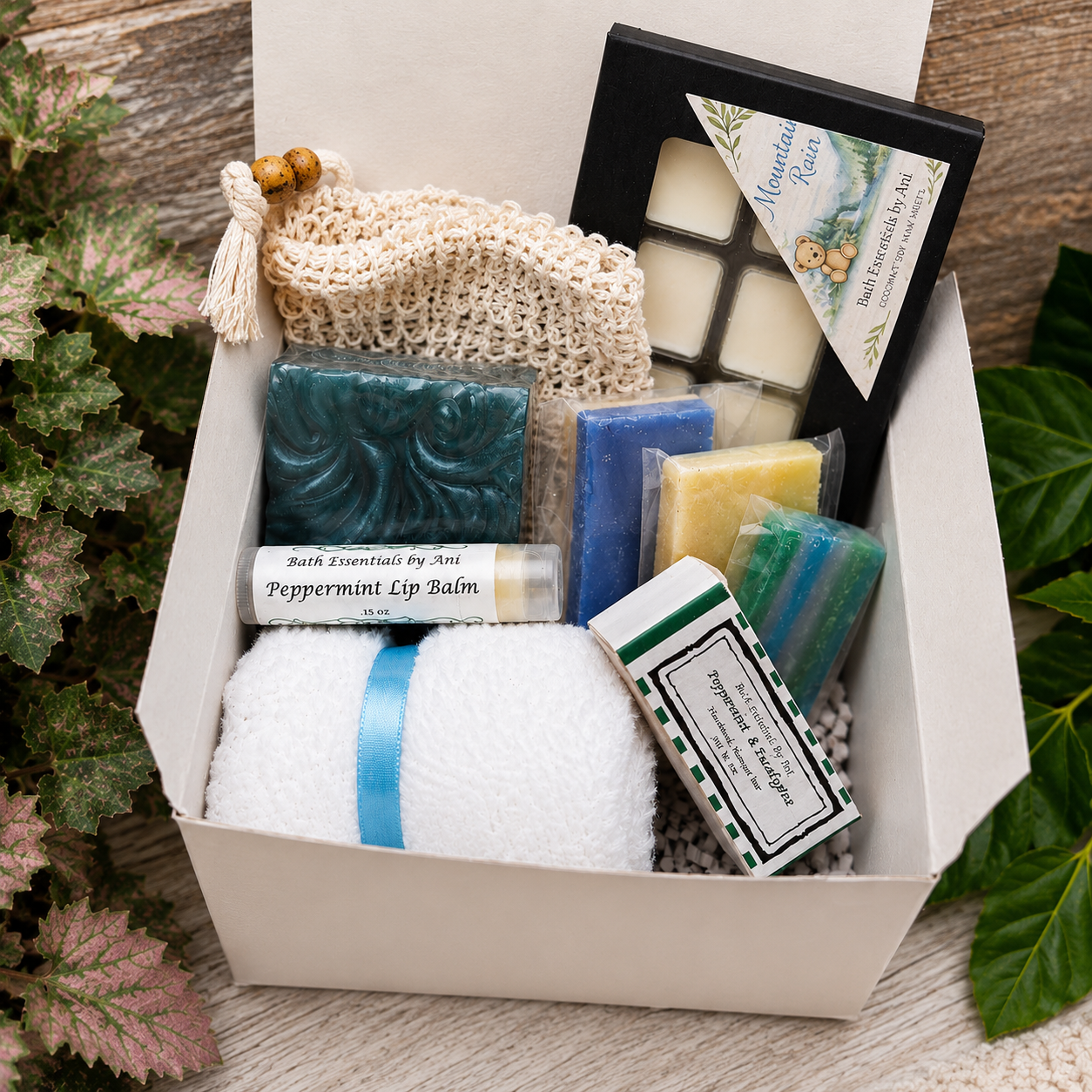Bath gift box with teal soap bars, wax melts, lip balm, and knit scrub pouch