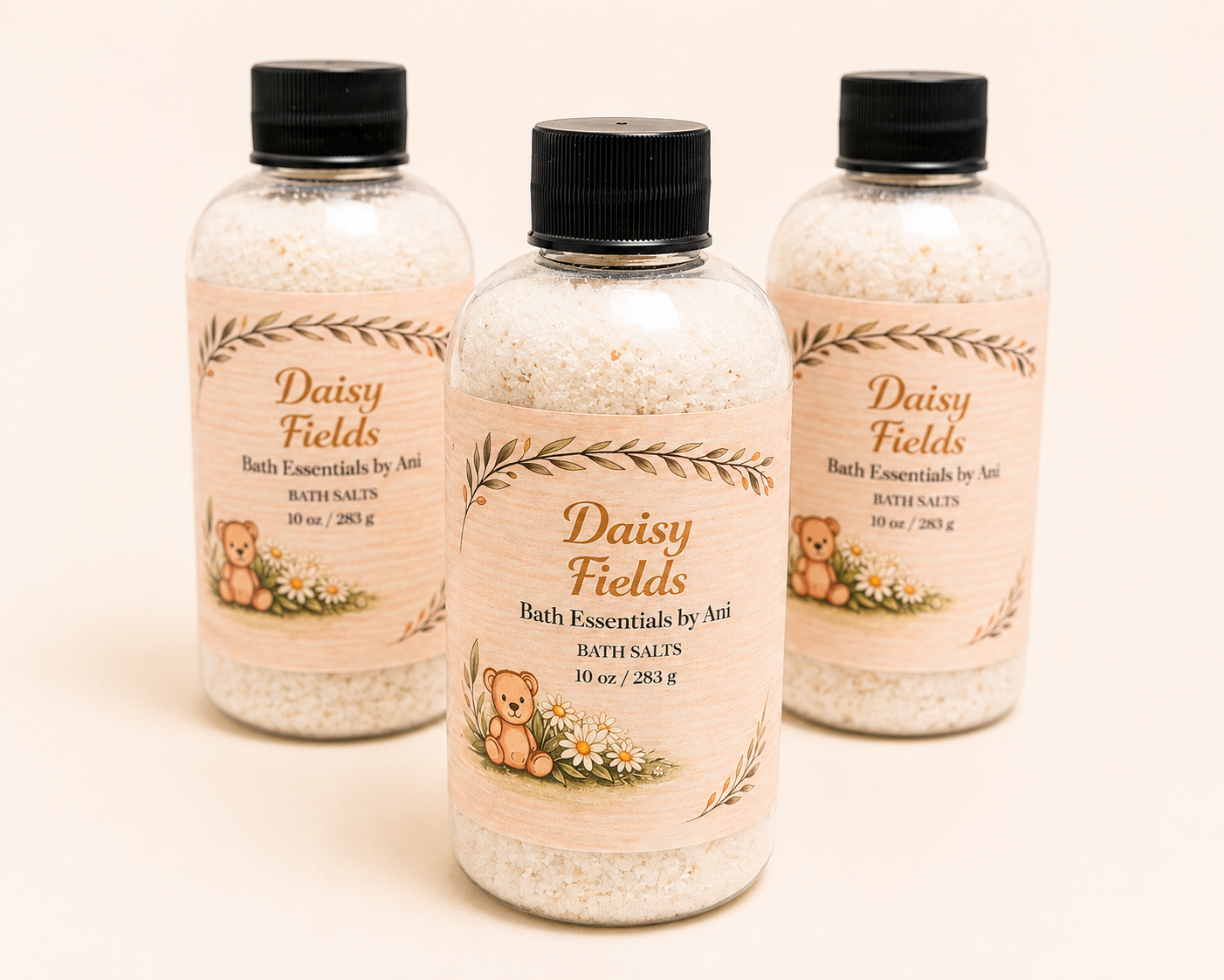 Three bottle bath essentials with black caps, labeled Daisy Fields, filled with pale granules