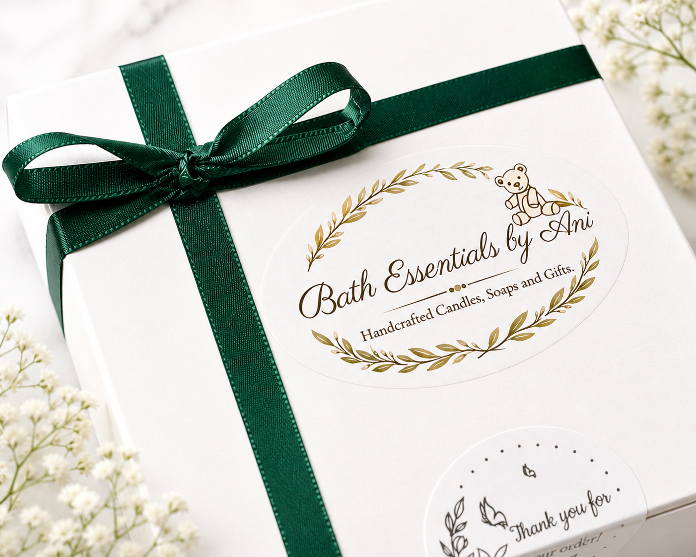 White gift box lid with green satin ribbon and gold botanical logo