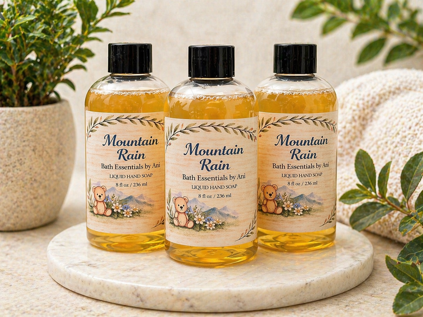 Bottle of bath essentials labeled Mountain Rain, shown in three amber bottles