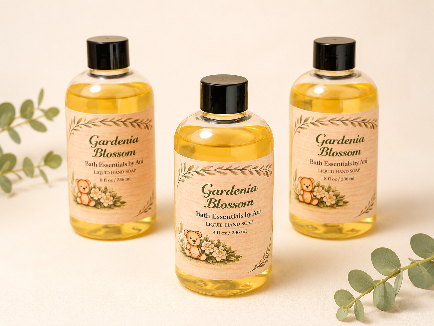 Gardenia blossom bath essentials bottles, amber liquid with black caps, three-pack