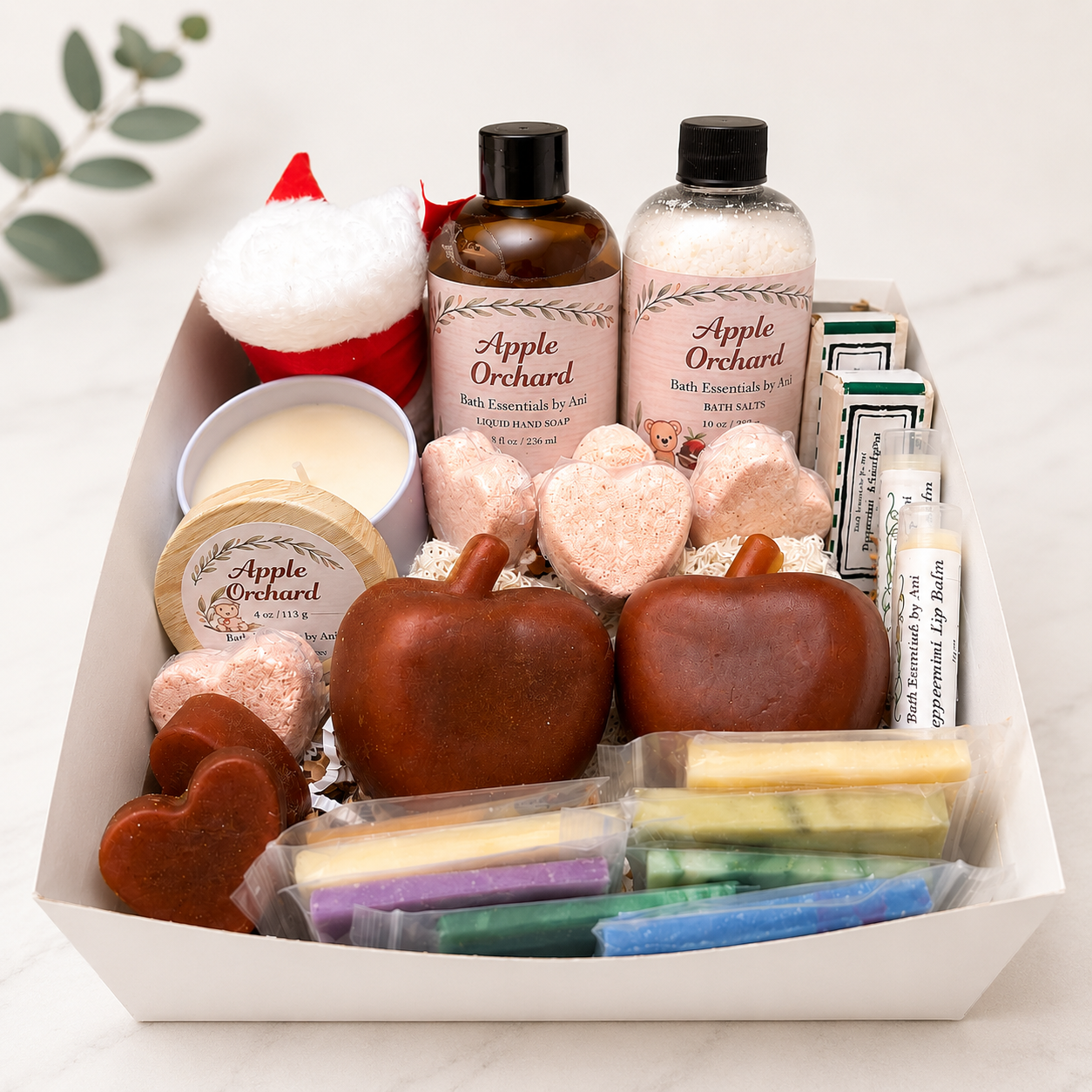 Apple-themed self-care gift basket with apple-shaped soaps, candle, and bath products