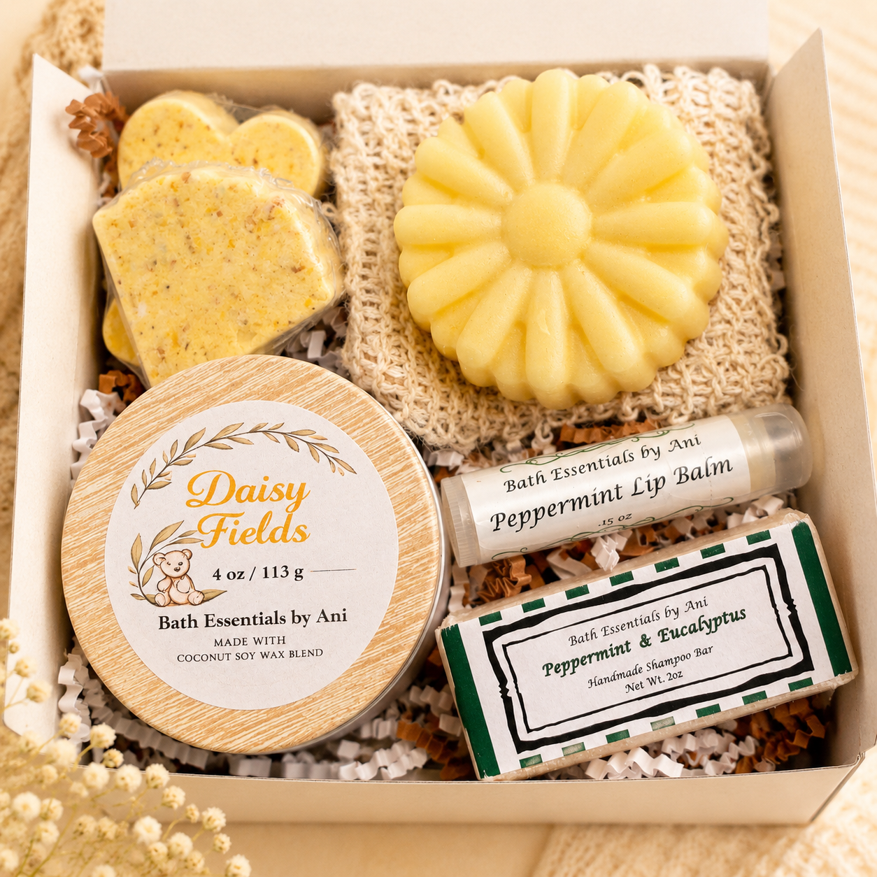 Bath gift box with yellow soap bar, daisy-shaped soap, lip balm tube, and labeled soap bars