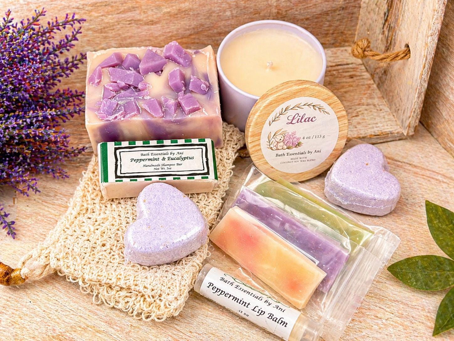 Lilac spa gift set with lavender bars, wax melts, and heart-shaped bath bombs on wood