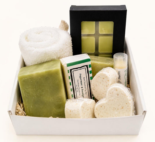 Spa gift box with green handmade soaps and folded white towel inside