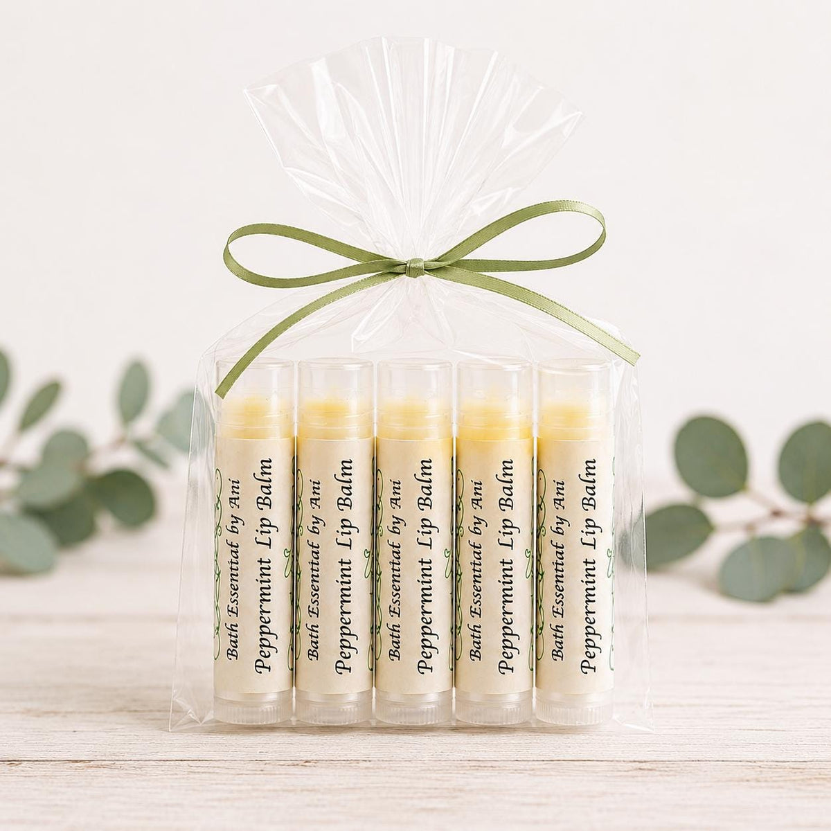Bagged peppermint lip balm favors: five clear tubes tied with green ribbon